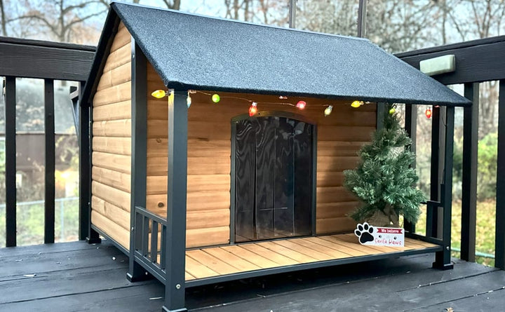 wooden dog house with a dark gray roof and black metal frame. The house has light natural wood siding, a black front door